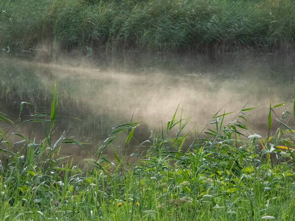 Красивый осенний утренний пейзаж озера с испарительным туманом, вызванным холодным воздухом, проходящим над более теплой водой