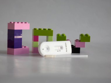 SARS-CoV-2 Antijen Hızlı Testi (nazal Swab), beyaz üzerine kenetlenmiş oyuncak tuğlaları arasında negatif sonuç veren bir çubuk ve test kaseti ile kendini test etmek için. COVID-19 Ag. Çocukluktaki salgın kavramı