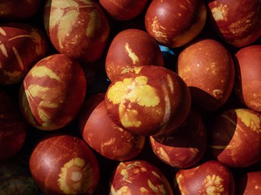 Doğal bitkilerle boyanmış Paskalya yumurtaları ve soğan kabuklarında kaynayan çiçek çiçekleri. Kahverengi yumurtaların üzerinde sarı desenler yaratmak için geleneksel bir yöntem.