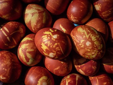 Doğal bitkilerle boyanmış Paskalya yumurtaları ve soğan kabuklarında kaynayan çiçek çiçekleri. Kahverengi yumurtaların üzerinde sarı desenler yaratmak için geleneksel bir yöntem.