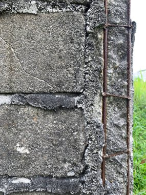 A rusted iron structure can be seen in the corner of the exposed adobe wall.