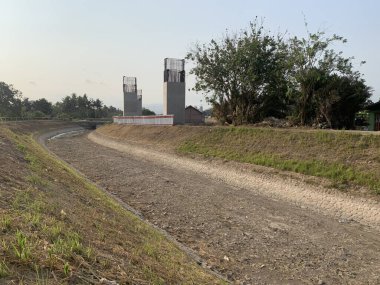 Kuru bir kanalizasyonun üzerinde asılı duran otoyol inşaatı beton çalışmalarının devam ettiğini gösteriyor. Altyapı ve mühendislik görselleri için ideal.