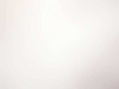 Beyaz bir duvarın önünde duran takım elbiseli ve kravatlı bir adam.