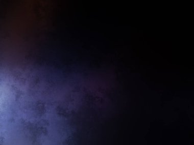 Takım elbiseli ve kravatlı bir adam karanlık bir arka planın önünde duruyor.