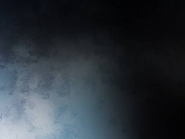 Takım elbiseli ve kravatlı bir adam karanlık bir arka planın önünde duruyor.