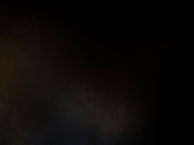 Siyah bir arka planın önünde duran takım elbiseli ve kravatlı bir adam.