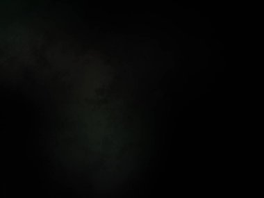 Siyah gömlekli bir adam tenis raketi tutuyor.