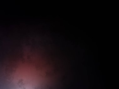 Karanlık bir yüzeyde kaykay süren bir insan.