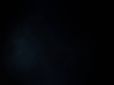 Siyah gömlekli bir adam tenis raketi tutuyor.