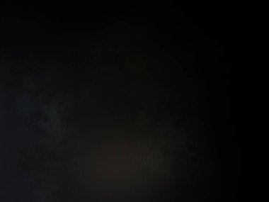 Siyah bir arka planın önünde duran takım elbiseli ve kravatlı bir adam.