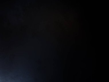 Siyah gömlekli bir adam tenis raketi tutuyor.