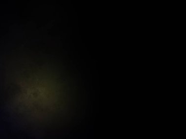 Siyah bir arka planın önünde duran takım elbiseli ve kravatlı bir adam.