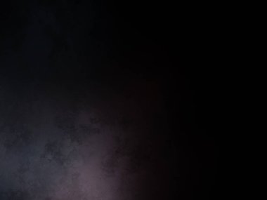 Siyah bir arka planın önünde duran takım elbiseli ve kravatlı bir adam.