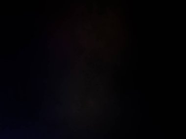 Takım elbiseli ve kravatlı bir adam mikrofonun önünde duruyor.