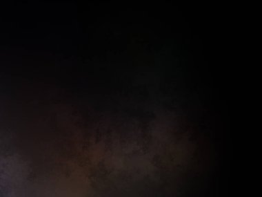 Takım elbiseli ve kravatlı bir adam karanlık bir arka planın önünde duruyor.