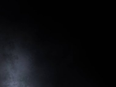 Siyah gömlekli bir adam tenis raketi tutuyor.