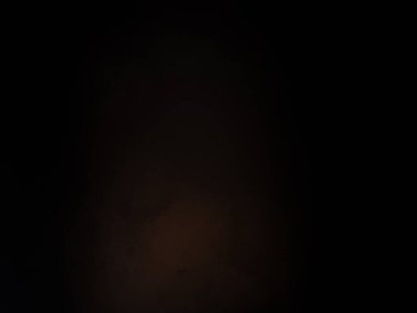 Karanlıkta elinde kamerayla bekleyen biri.