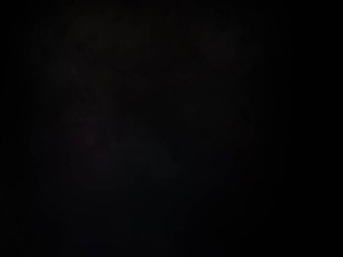 Elinde mikrofon tutan takım elbiseli ve kravatlı bir adam.