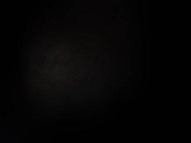 Karanlık gökyüzünde dolunay ve siyah bir arka plan.