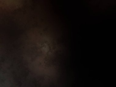 Takım elbiseli ve kravatlı bir adam karanlık bir arka planın önünde duruyor.