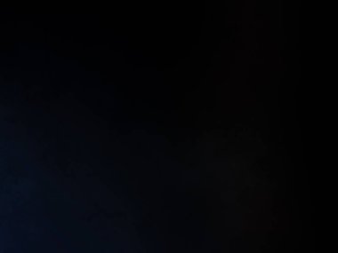 Elinde mikrofon tutan takım elbiseli ve kravatlı bir adam.