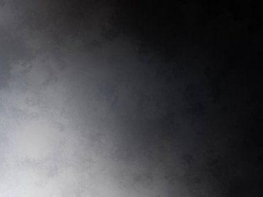 Siyah bir arka planın önünde duran takım elbiseli ve kravatlı bir adam.