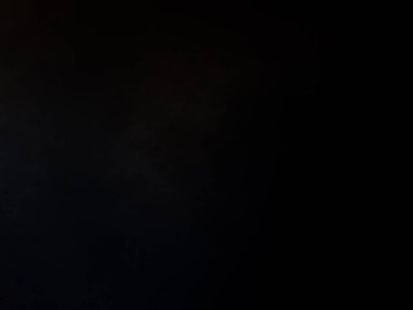 Elinde mikrofon tutan takım elbiseli ve kravatlı bir adam.