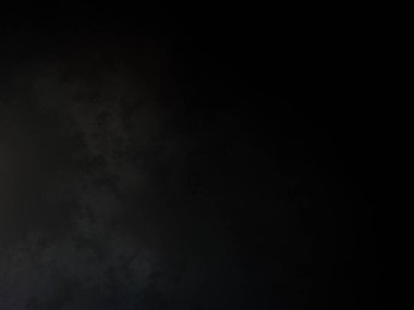 Siyah gömlekli bir adam tenis raketi tutuyor.