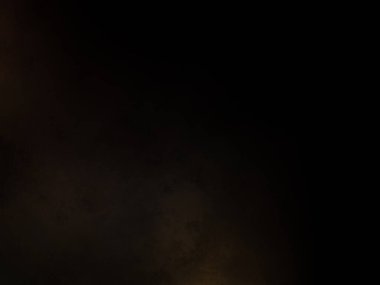 Takım elbiseli ve kravatlı bir adam ateşin önünde duruyor.