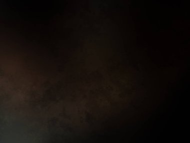 Siyah bir arka planın önünde duran takım elbiseli ve kravatlı bir adam.