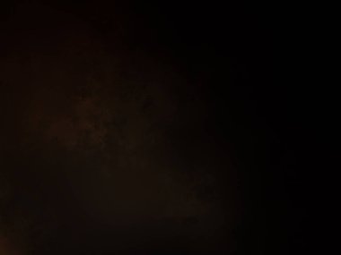 Takım elbiseli ve kravatlı bir adam ateşin önünde duruyor.