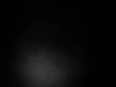 Karanlıkta parlayan bir ışıkla siyah bir arkaplan.