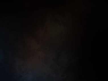 Takım elbiseli ve kravatlı bir adam karanlık bir arka planın önünde duruyor.