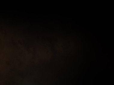 Takım elbiseli ve kravatlı bir adam ateşin önünde duruyor.