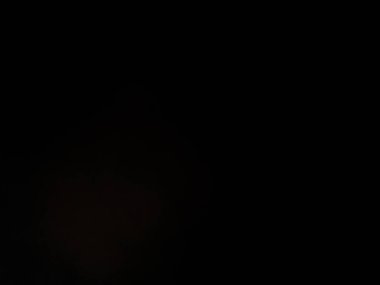 Takım elbiseli ve kravatlı bir adam mikrofonun önünde duruyor.