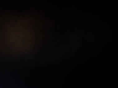 Takım elbiseli ve kravatlı bir adam mikrofonun önünde duruyor.