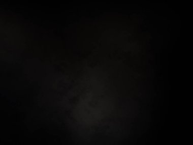 Siyah gömlekli bir adam elinde kamera tutuyor.