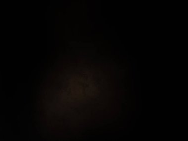 Karanlık gökyüzünde dolunay ve siyah bir arka plan.