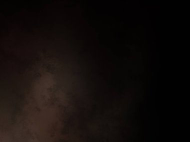 Siyah bir arka planın önünde duran takım elbiseli ve kravatlı bir adam.