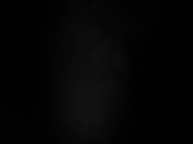 Siyah gömlekli bir adam elinde kamera tutuyor.