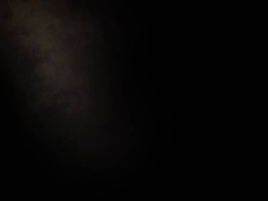 Karanlıkta duran takım elbiseli ve kravatlı bir adam.