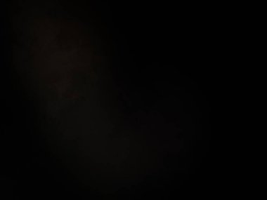 Elinde mikrofon tutan takım elbiseli ve kravatlı bir adam.