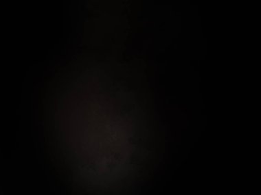 Siyah bir arka planın önünde duran takım elbiseli ve kravatlı bir adam.