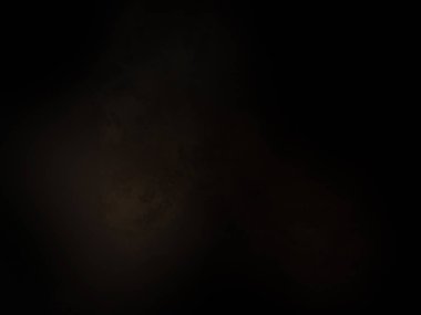 Siyah bir arka planın önünde duran takım elbiseli ve kravatlı bir adam.