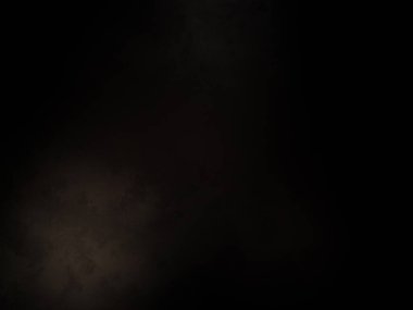 Siyah bir arka planın önünde duran takım elbiseli ve kravatlı bir adam.