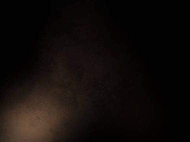 Takım elbiseli ve kravatlı bir adam karanlık bir arka planın önünde duruyor.