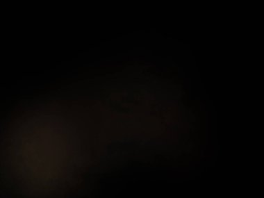 Karanlıkta duran takım elbiseli ve kravatlı bir adam.