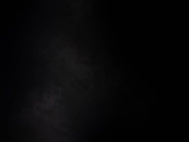 Siyah gömlekli bir adam elinde kamera tutuyor.