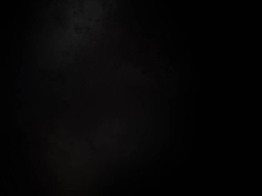 Siyah gömlekli bir adam elinde kamera tutuyor.