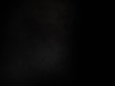 Siyah bir arka planın önünde duran takım elbiseli ve kravatlı bir adam.